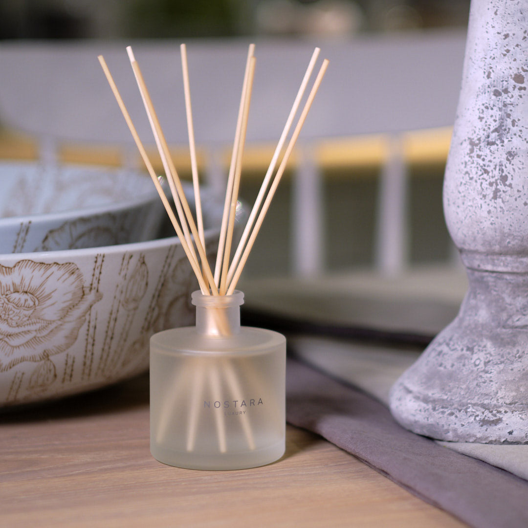 Nostara scented reed diffuser on a dressed table with stoneware bowls